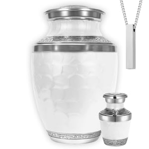 May include: White urn with a silver lid and trim, featuring a textured pattern. A smaller matching urn and a silver pendant necklace are also shown. The urns are designed with a decorative floral pattern around the top and bottom.