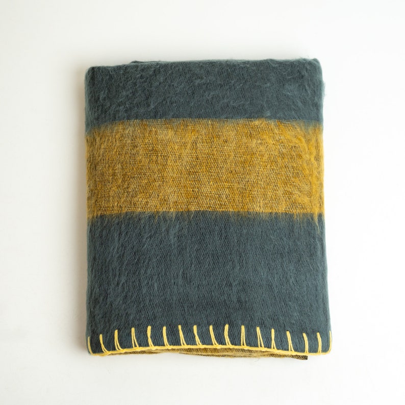 May include: A dark grey and mustard yellow striped throw blanket with a yellow stitched border.