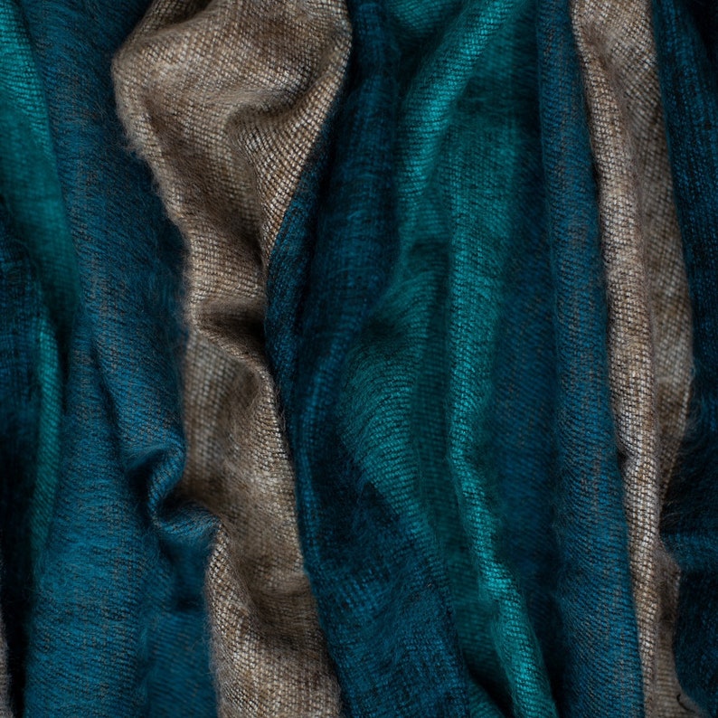 May include: A close-up of a teal and beige striped fabric. The fabric is soft and textured, with a subtle sheen.