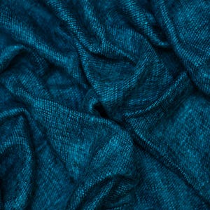May include: Close-up of a teal fabric with a woven texture. The fabric is draped, creating soft folds and shadows. The color is a deep, rich teal, with subtle variations in tone. The overall appearance suggests a luxurious textile, possibly for clothing or home decor.