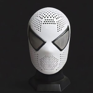 Op de afbeelding: Witte superheldenmasker met zwarte oogkaders en een geperforeerd ontwerp. Het masker wordt getoond op een zwarte standaard, die de volledige gezichtsbedekking en ingewikkelde details laat zien. Ontworpen voor cosplay of kostuums.