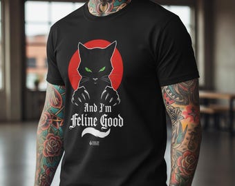 Könnte beinhalten: Schwarzes T-Shirt mit einer Grafik einer schwarzen Katze mit grünen Augen vor einem roten Kreis. Der Text "And I'm Feline Good" steht unter der Katze. Das T-Shirt hat einen Rundhalsausschnitt.