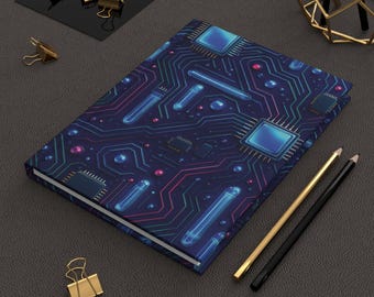 May include: A hardcover notebook with a circuit board design in blue, teal, and pink. The notebook is surrounded by gold and black pencils, gold binder clips, and a geometric gold sculpture.