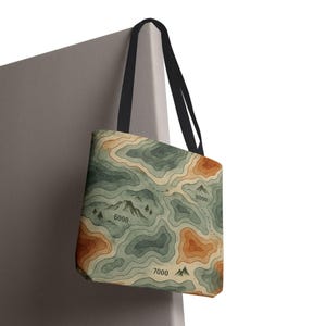 Bolsa de mano con diseño topográfico de montaña, bolsa de compras ecológica, regalo para amantes de la naturaleza, perfecta para senderismo o viajes, elegante y funcional.