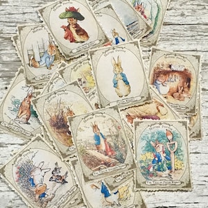 Puede incluir: Una colección de tarjetas de intercambio vintage de Peter Rabbit con ilustraciones de Peter Rabbit en varias escenas del libro. Las tarjetas están impresas en papel texturizado con un borde marrón y dorado. El texto en las tarjetas dice "The Tale of Peter Rabbit".