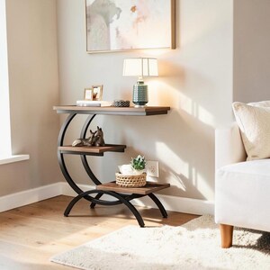 Peut inclure: Une table d'appoint à trois niveaux avec une structure en métal foncé et des étagères en bois. L'étagère supérieure contient une lampe et des objets décoratifs. L'étagère du milieu présente une figurine de cheval et l'étagère inférieure un petit panier avec une plante.