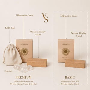 May include: A comparison of two sets of affirmation cards. The premium set includes a small bag, crystals, and a wooden display stand. The basic set includes affirmation cards and a wooden display stand. Both sets have the text "Affirmation Cards".