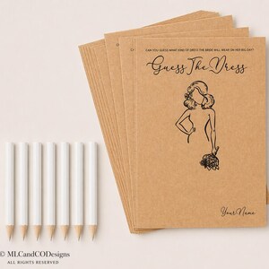 May include: A stack of kraft paper game cards with the text "Guess The Dress" and a bride illustration. White pencils are arranged beside the cards. The text "Can you guess what kind of dress the bride will wear on her big day?" is at the top.