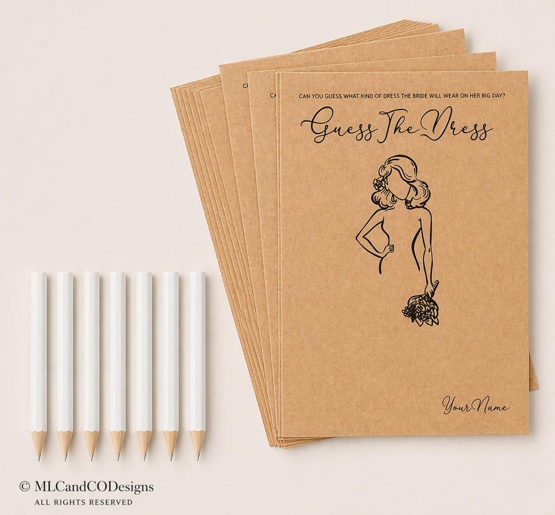 May include: A stack of kraft paper game cards with the text "Guess The Dress" and a bride illustration. White pencils are arranged beside the cards. The text "Can you guess what kind of dress the bride will wear on her big day?" is at the top.