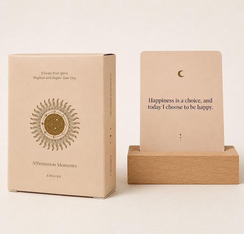 May include: A beige box and card set with the text "Elevate Your Spirit, Brighten and Inspire Your Day" and "Affirmation Moments." The card reads "Happiness is a choice, and today I choose to be happy." A wooden card holder is in the image.