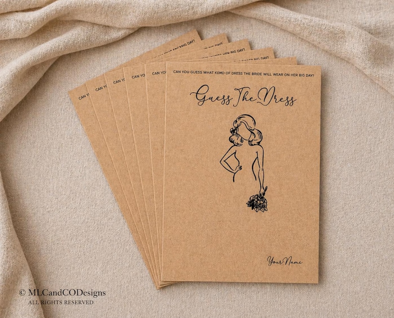 May include: A pile of tan kraft paper cards, each with the text "Guess The Dress" and a drawing of a woman. The cards have the text "Can You Guess What Kind of Dress the Bride Will Wear on Her Big Day?" printed on them.