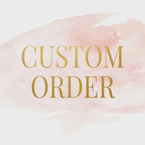 Könnte beinhalten: Der Text CUSTOM ORDER ist in einer fetten, goldfarbenen Serifenschrift geschrieben. Die Buchstaben sind zentriert und über einem weichen, blassrosa Aquarellhintergrund platziert, der unterschiedliche Deckkraft und Pinselstrichstrukturen aufweist.