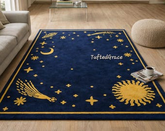 May include: A navy blue rectangular rug with a celestial design. The rug features yellow stars, a crescent moon, a sun, and a shooting star pattern. The rug has a yellow border and the text "TuftedGrace".