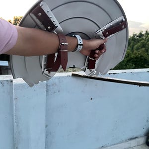 Peut inclure: Un bouclier argent&eacute; de forme arrondie avec des rainures concentriques. Il est &eacute;quip&eacute; de sangles en cuir marron et d'&eacute;l&eacute;ments m&eacute;talliques pour la fixation au bras. Le bouclier est tenu par une personne.