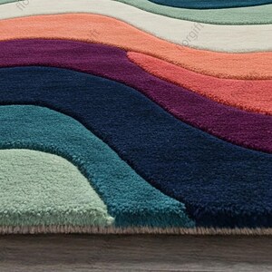 May include: A colorful area rug with a wave-like design. The rug features a variety of colors, including teal, navy, purple, coral, and white. The rug is made of a soft, plush material.