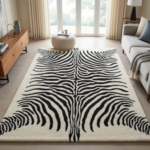 Puede incluir: Una alfombra rectangular grande con un diseño de rayas de cebra. La alfombra presenta un fondo color crema con rayas negras audaces, creando un contraste llamativo. El diseño imita el patrón natural del pelaje de una cebra, agregando un toque salvaje a la habitación.