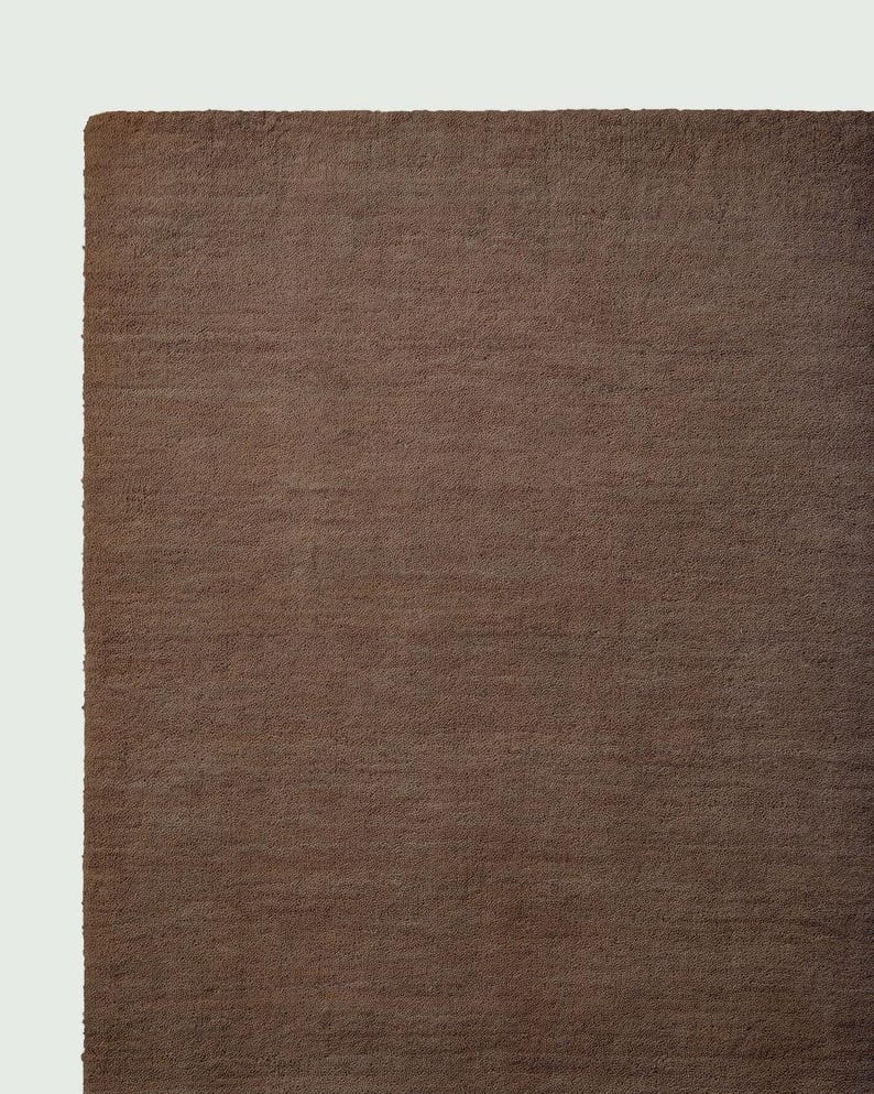 Hand tufted solid brown wool rug in modern living room, minimalist neutral carpet with soft texture and luxury finish for home decor