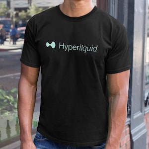 May include: Black crew neck t-shirt with the word "Hyperliquid" printed in a light teal color. The shirt features a teal-colored abstract design to the left of the text. The t-shirt is made of a soft material.
