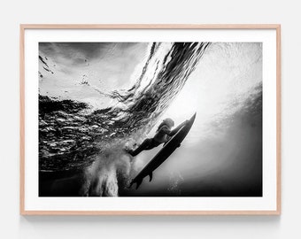 Könnte beinhalten: Ein Schwarzweißfoto eines Surfers, der unter Wasser eine Welle reitet. Der Surfer ist vor dem hellen Licht der Wasseroberfläche silhouettiert.