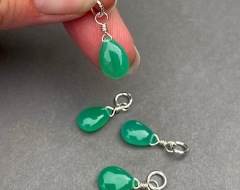 Puede incluir: Cuatro abalorios de gota de piedra preciosa verde con lazos de alambre plateado. Los abalorios miden aproximadamente 2,5 cm de largo.