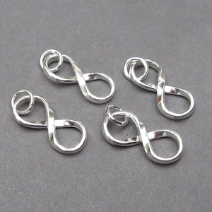 May include: Four silver infinity symbol charms with a loop at the top for attaching to jewelry.