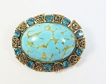 Broche broche des années 1920, petit verre d'art tchèque bohème vintage cristaux strass bleu turquoise vif et broche ovale en filigrane de laiton