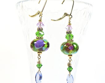 Orecchini botanici, perline di vetro artistico verde-viola, placcatura in oro 14 carati e cristalli Swarovski, chiusura a clip disponibile.