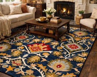 Puede incluir: Una alfombra azul marino con un diseño floral en rojo, amarillo y crema. La alfombra está en un salón con chimenea, sofá y mesa de centro. El diseño de la alfombra presenta grandes flores estilizadas y enredaderas.