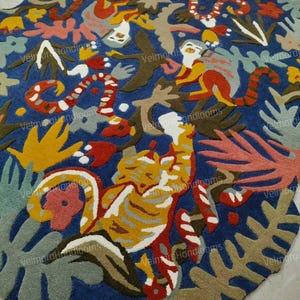 Può includere: Un vivace tappeto fatto a mano con uno sfondo blu scuro. Il tappeto presenta un design astratto colorato con animali stilizzati, piante e forme organiche in tonalità di rosso, giallo, arancione, verde e marrone. Il design del tappeto è intricato.