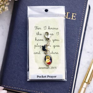 May include: A pocket prayer charm with a silver clasp, a small oval image of Jesus, and decorative beads. The charm is packaged with a card that has the text "For I know the plans I have for you, declares the Lord, plans to give you hope and a future. Jeremiah 29:11."
