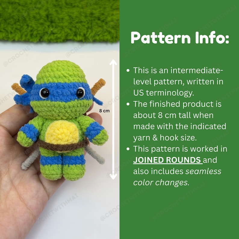 May include: A handmade amigurumi doll, approximately 3 inches tall, in the shape of a cartoon character. The doll is primarily green and blue, with brown accents and two small swords. The doll is made with crochet techniques.