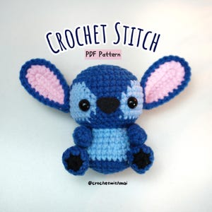 Może przedstawiać: Ręcznie robiona szydełkowa lalka Stitch w odcieniach niebieskiego, jasnoniebieskiego, różowego i czarnego. Lalka ma duże uszy, czarny nos i dwa czarne oczy. Tekst "CROCHET STITCH PDF Pattern" znajduje się na górze, a "@crochetwithmai" na dole.