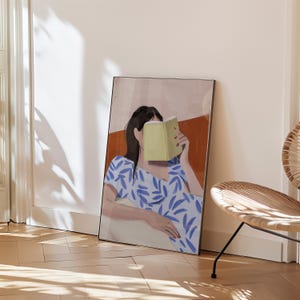 May include: An art print featuring a person reading a book, with the book obscuring their face. The person is wearing a blue and white patterned dress. The background has a neutral color palette with a brown accent.