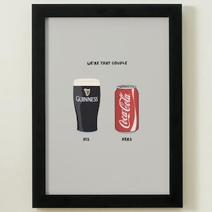 Puede incluir: Impresi&oacute;n enmarcada con una pinta de Guinness y una lata de Coca-Cola, etiquetadas como "His" y "Hers". El texto "WE'RE THAT COUPLE" est&aacute; encima de las bebidas. La imagen tiene un fondo gris.