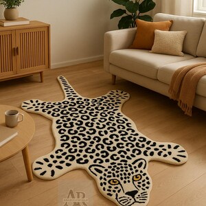 May include: A cream-coloured leopard-shaped rug with black spots and a detailed face with yellow eyes. The rug is on a wooden floor in a living room, with a sofa and side table in view. The rug's design is eye-catching.