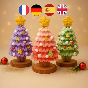 May include: Three handmade crochet Christmas trees in purple, orange, and green, each with a yellow star topper. The trees are decorated with white ball ornaments and small decorative shapes. Each tree sits on a small wooden base.