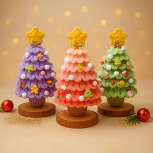 May include: Three handmade crochet Christmas trees in purple, coral, and green, each with a yellow star topper and decorative ornaments. The trees sit on small wooden bases, perfect for holiday decor.