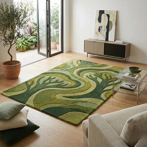 May include: A green area rug with a tree design in varying shades of green. The rug is rectangular and placed on a hardwood floor in a living room setting. The room includes a sofa, coffee table, and a potted olive tree.