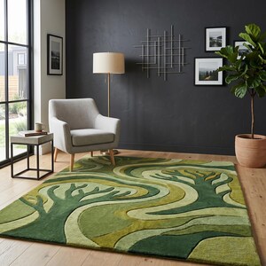 May include: A green area rug with a tree design in varying shades of green. The rug is rectangular and placed on a hardwood floor. A gray armchair and a side table are in the background.