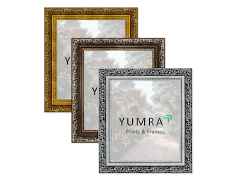 May include: Three ornate picture frames in gold, brown, and silver. Each frame has a detailed, embossed design around the edges. The frames are empty, ready for prints or photos. The brand name "YUMRA Prints & Frames" is visible on the front frame.