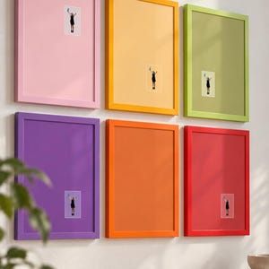 Può includere: Un set di sei cornici da parete rettangolari nei colori rosa, giallo, verde chiaro, viola, arancione e rosso. Ogni cornice contiene un passe-partout a tinta unita con una piccola foto centrata di una persona in abito nero con oggetto blu.