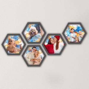 May include: A collection of five hexagonal photo frames with dark grey borders. Each frame displays a photograph of people and pets, set against a colourful abstract background. The frames are arranged on a white wall.