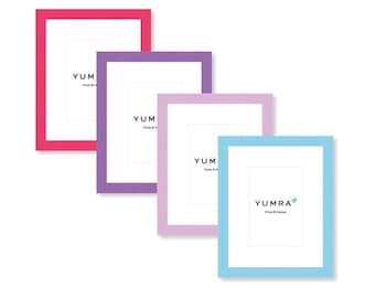 May include: Four colorful picture frames in shades of pink, purple, and blue. Each frame has a white interior and the text "YUMRA Prints & Frames". The frames are arranged diagonally against a white background.