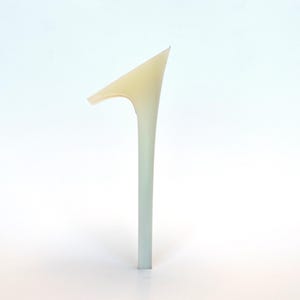 May include: A minimalist, abstract sculpture with a slender, vertical stem that transitions from a pale green to a light yellow at the top. The top features a sharp, angular shape with a curved extension.