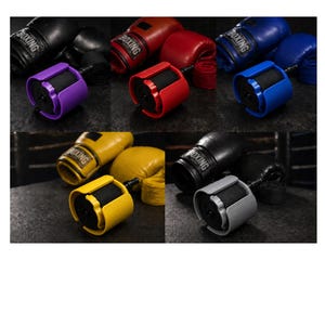 May include: An assortment of boxing gloves in black, red, blue, and yellow, paired with hand wraps and colored hand wrap rollers. The rollers are in purple, red, blue, yellow, and gray.