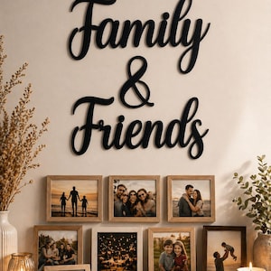 May include: A wall display featuring framed photos and a black cursive "Family & Friends" sign. The photos are in various sizes and feature family portraits. Decorative elements include vases, candles, and greenery.