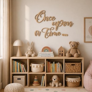 May include: A light wood bookshelf with books, toys, and decorative items. The wall above features wooden script that reads "Once upon a Time...". A stuffed bunny, teddy bear, and rainbow decor are visible.