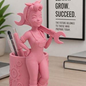 May include: Pink pen holder shaped like a woman in overalls holding a wrench. The pen holder has a cylindrical base with gear designs. The image includes pens and a sign that says "STUDY. LEARN. GROW. SUCCEED."
