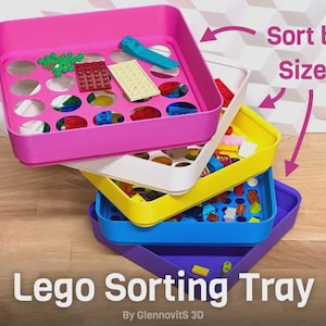 May include: Stack of colorful Lego sorting trays in pink, white, yellow, blue, and purple. Each tray contains Lego bricks of various colors and shapes. Text on the image reads "Lego Sorting Tray" and "Sort by Size!"