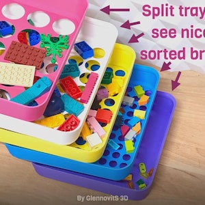 May include: Stack of colorful plastic trays filled with assorted toy bricks. The trays are pink, white, yellow, blue, and purple. Text on the image reads "Split trays to see nicely sorted bricks."